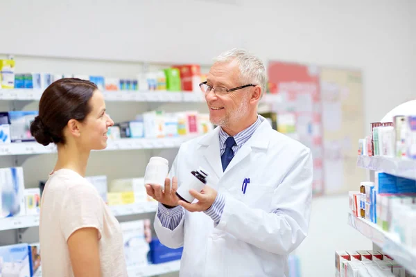 Boticario y mujer con droga en la farmacia — Foto de Stock