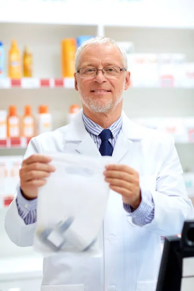 Senior apothecary at pharmacy cash register — Stock Photo, Image