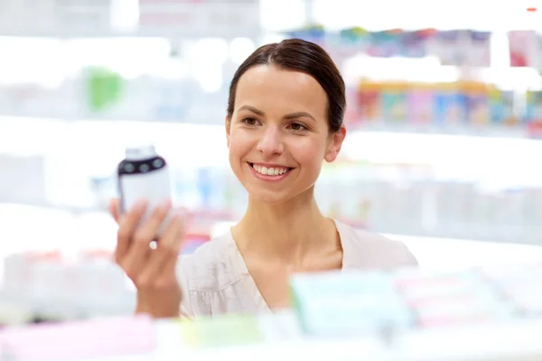 Female customer choosing drugs at pharmacy — Stock Photo, Image