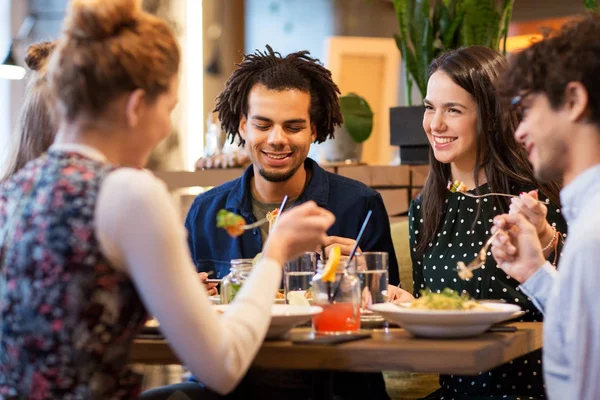 Amigos felizes comendo no restaurante — Fotografia de Stock