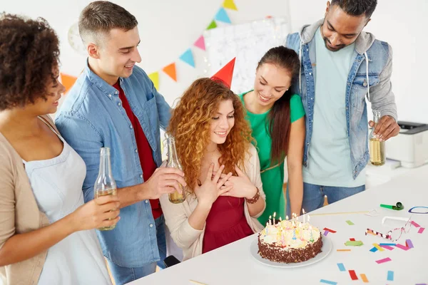 Glada medarbetare med tårta på office födelsedagsfest — Stockfoto