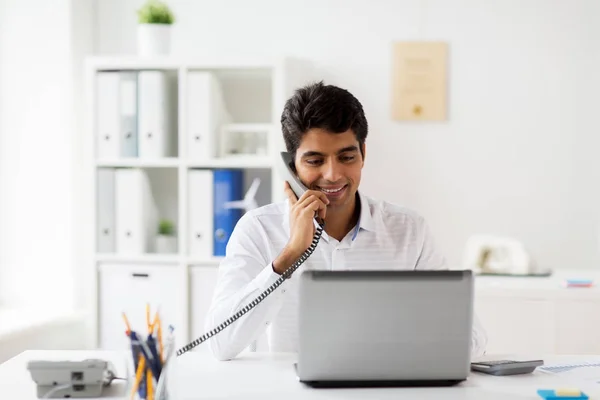 Gelukkig zakenman opgeroepen bureautelefoon op kantoor — Stockfoto
