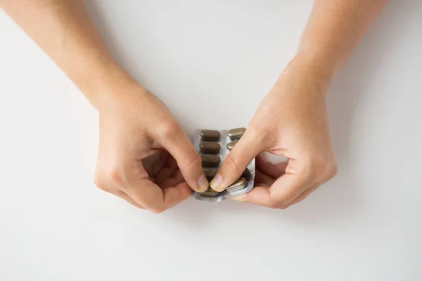 Woman hands opening pack of medicine pills — Stock Photo, Image