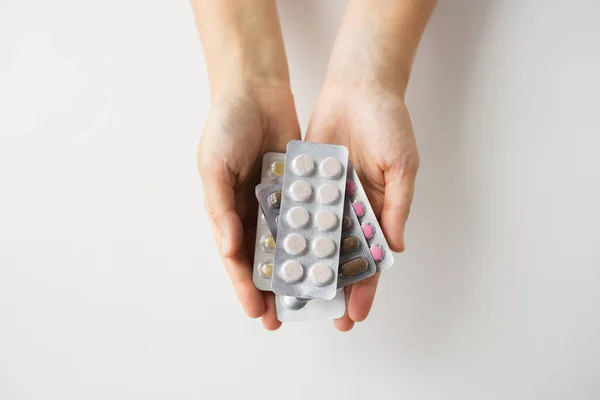 Manos de mujer sosteniendo paquetes de píldoras — Foto de Stock