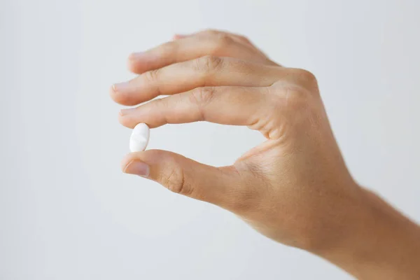 Close up of hand holding medicine pill — Stock Photo, Image