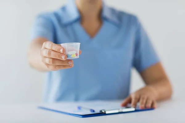 Close up of doctor with pills in medical cup — Stock Photo, Image