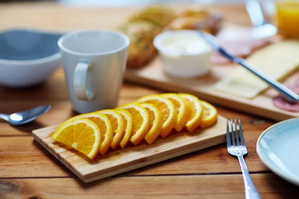 木製のテーブルにオレンジと他の食品をスライス — ストック写真