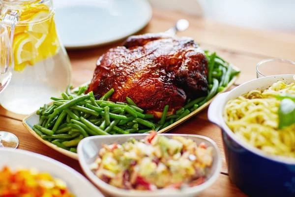 Roast chicken with garnish of green beans on table — Stock Photo, Image