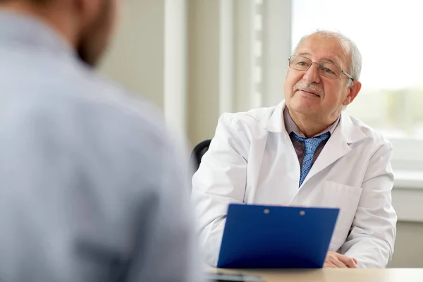 Kıdemli doktor erkek hasta hastanede konuşurken — Stok fotoğraf