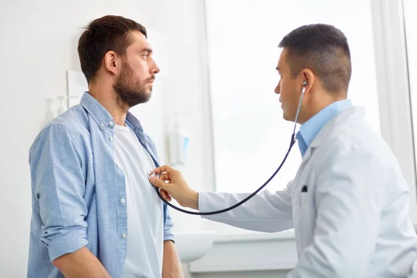 Arts met de stethoscoop en patiënt in ziekenhuis — Stockfoto