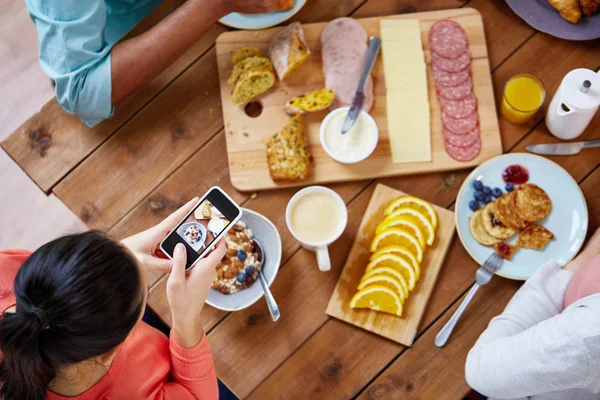 Kobiety z smartfonów jedzenia przy stole — Zdjęcie stockowe