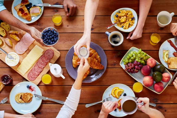 Pessoas tomando café da manhã à mesa com alimentos — Fotografia de Stock