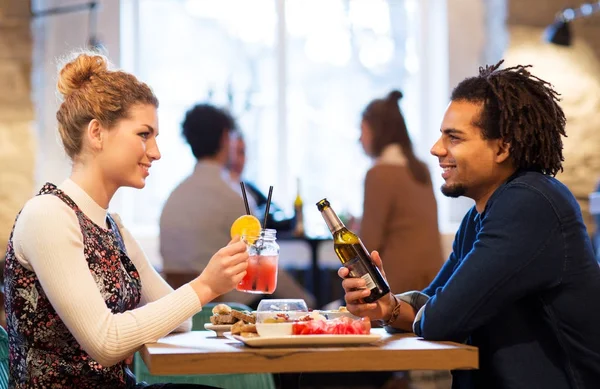 Pareja feliz con bebidas en el restaurante o bar —  Fotos de Stock