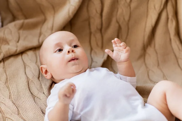 Sladký chlapeček baby, ležící na pletené deky — Stock fotografie