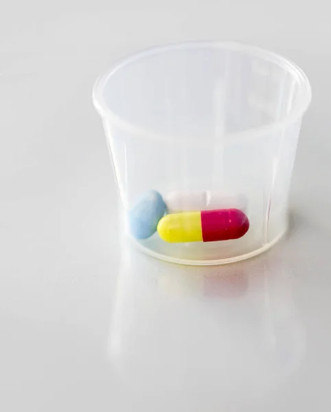 Close-up de pílulas e cápsula no copo de medicina — Fotografia de Stock