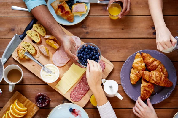 Pessoas tomando café da manhã à mesa com alimentos — Fotografia de Stock