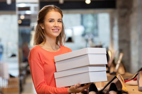 Mulher ou assistente de loja com caixas de sapato na loja — Fotografia de Stock