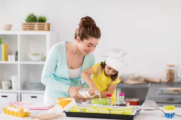 Glückliche Mutter und Tochter backen Cupcakes zu Hause — Stockfoto