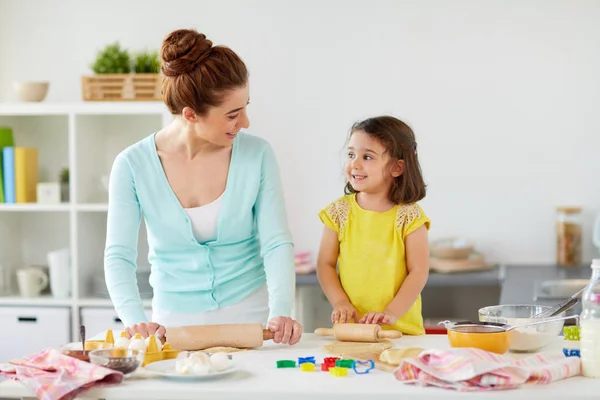 Feliz madre e hija haciendo galletas en casa —  Fotos de Stock