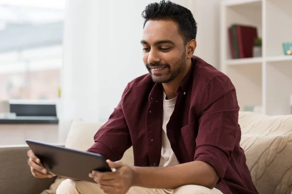 Hombre sonriente con la tableta PC en casa — Foto de Stock