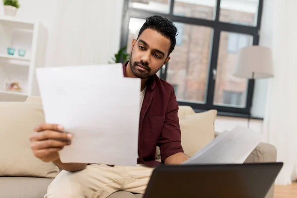 Upset man with laptop and papers at home — Stock Photo, Image