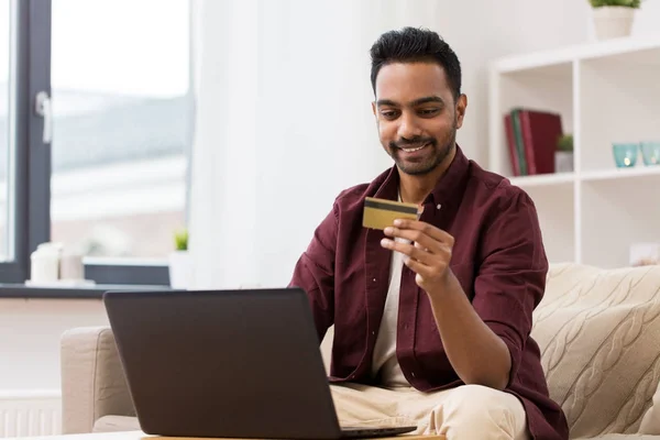 Uśmiechnięty mężczyzna z laptopa i karty kredytowej w domu — Zdjęcie stockowe