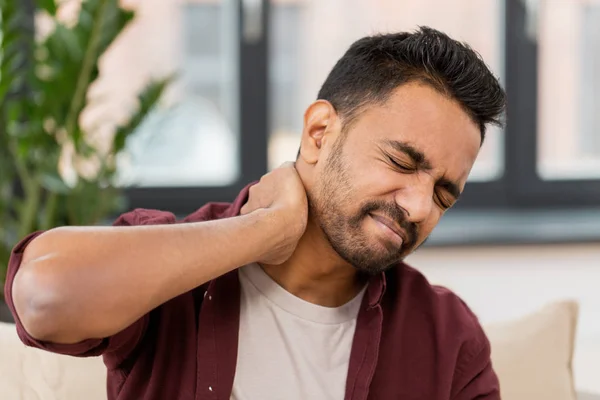 Hombre infeliz que sufre de dolor de cuello en casa —  Fotos de Stock