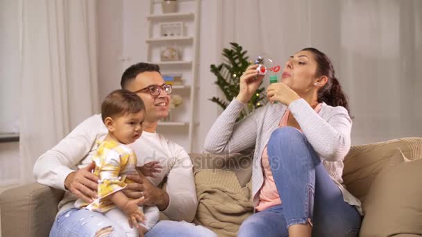 Família feliz com bebê e bolhas de sabão em casa — Vídeo de Stock