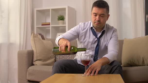 Алкоголик наливает красное вино в бокал дома — стоковое видео
