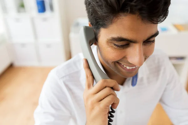 Feliz hombre de negocios llamando al teléfono de escritorio en la oficina — Foto de Stock