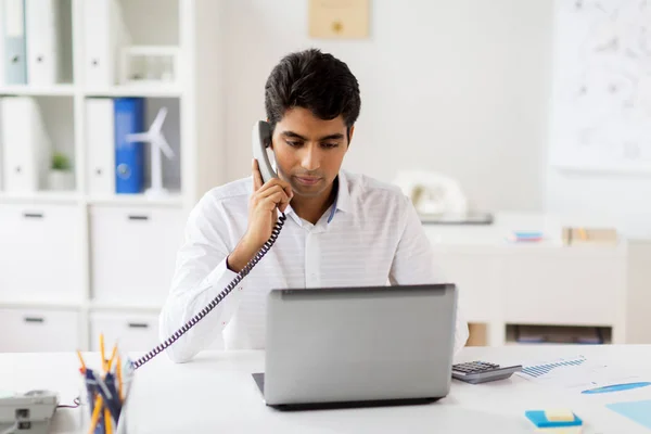 Zakenman opgeroepen bureautelefoon op kantoor — Stockfoto