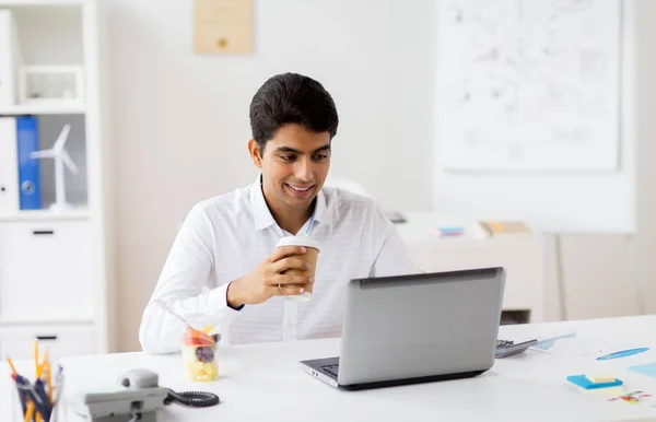 Homme d'affaires avec ordinateur portable boire du café au bureau — Photo