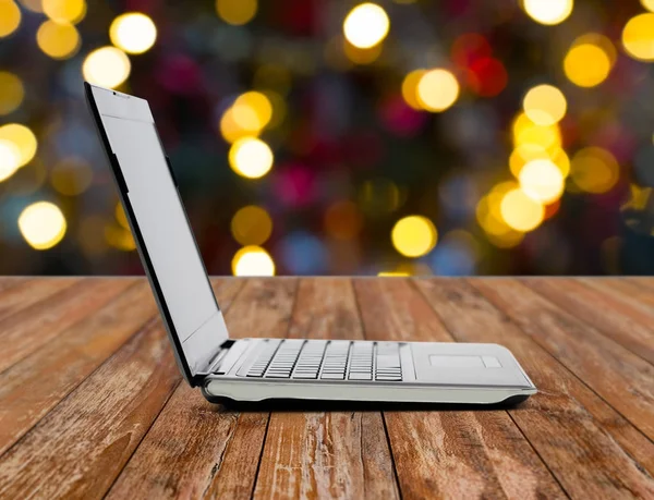 Laptop über Weihnachtsbeleuchtung — Stockfoto