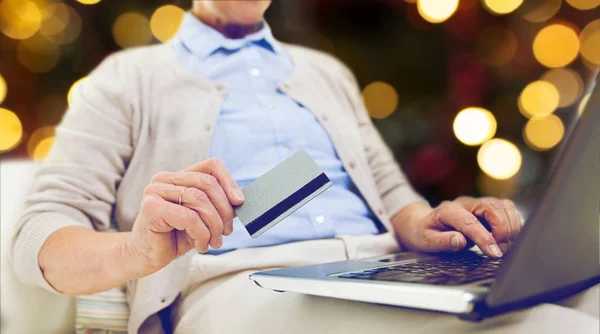 Mulher sênior com laptop e cartão de crédito — Fotografia de Stock