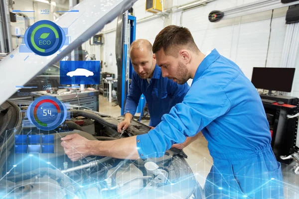 Hombres mecánicos con llave inglesa reparación de coches en el taller —  Fotos de Stock