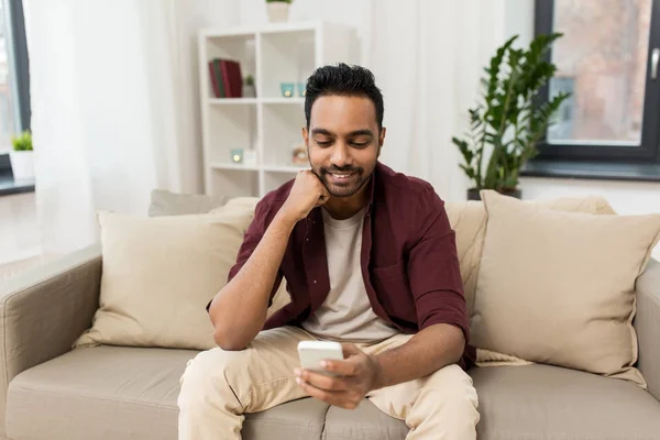 Hombre feliz con smartphone en casa —  Fotos de Stock