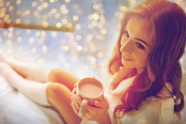 Lycklig kvinna med kopp choklad i sängen hemma — Stockfoto
