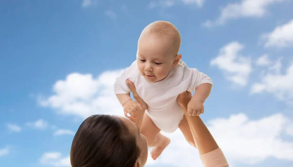 Mãe feliz brincando com o menino sobre o céu — Fotografia de Stock