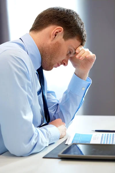 Stressad affärsman med papper på kontor — Stockfoto