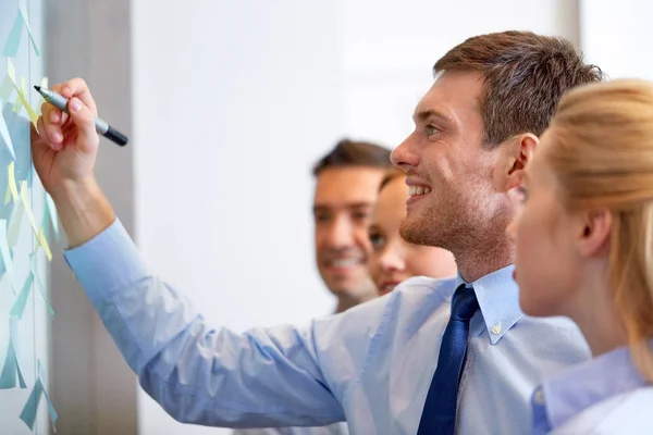 Business-Team mit Marker, der Haftnotizen schreibt — Stockfoto