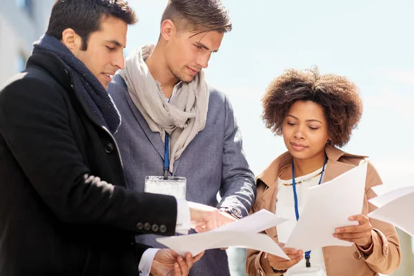 Equipo de negocios internacional con papeles al aire libre — Foto de Stock