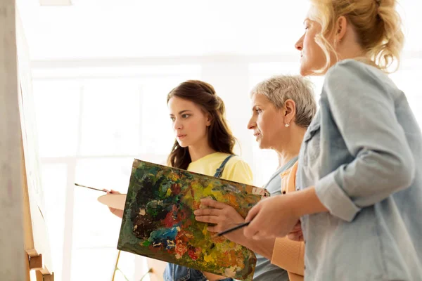 Women with brushes painting at art school — Stock Photo, Image