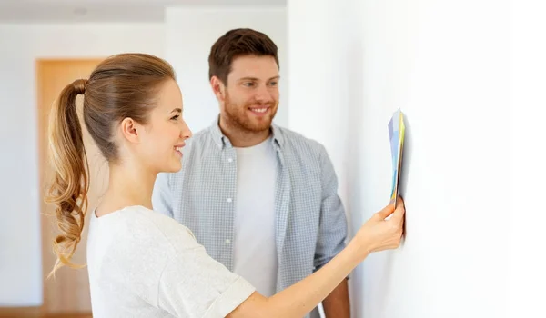 Happy couple with color samples at new home — Stock Photo, Image