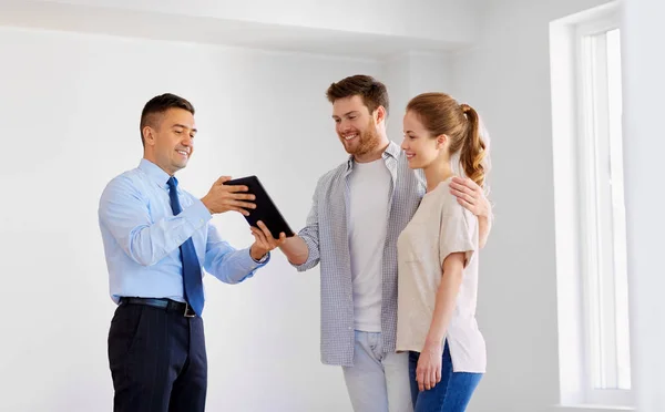 Ehepaar und Makler mit Tablet-PC im neuen Zuhause — Stockfoto