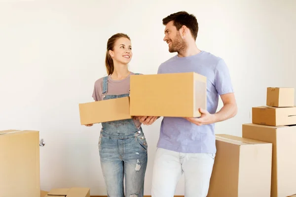 Happy couple with boxes moving to new home — Stock Photo, Image