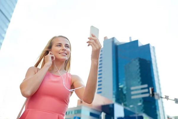 Jeune femme heureuse avec smartphone et écouteurs — Photo