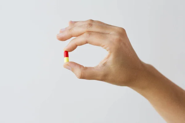 Close up of hand holding capsule of medicine — Stock Photo, Image