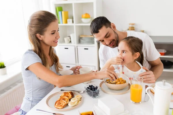 Счастливая семья, завтракающая дома — стоковое фото