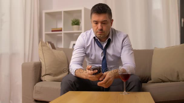 Alkoholiker mit Smartphone trinkt zu Hause Wein — Stockvideo