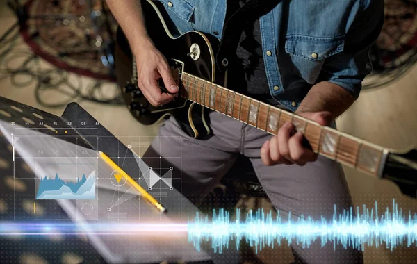 Homem com livro de música em stand tocando guitarra — Fotografia de Stock